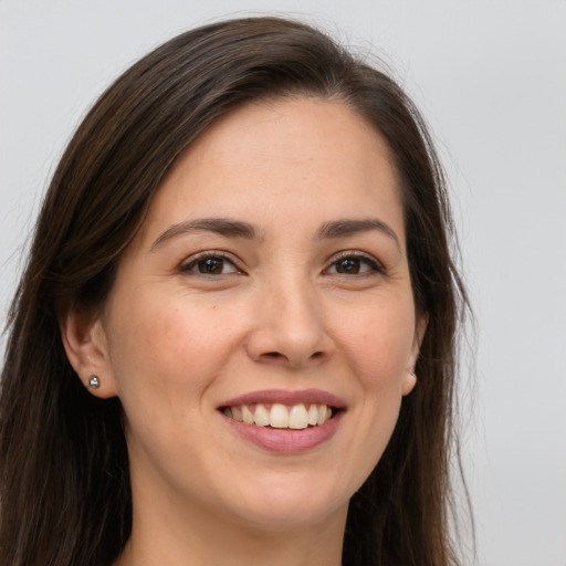 Joyful white young-adult female with long  brown hair and brown eyes