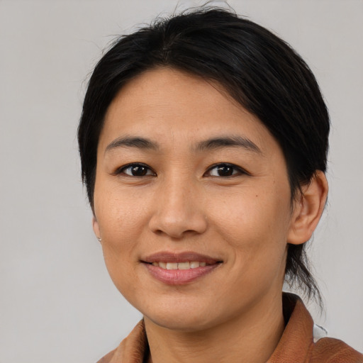 Joyful asian young-adult female with medium  brown hair and brown eyes