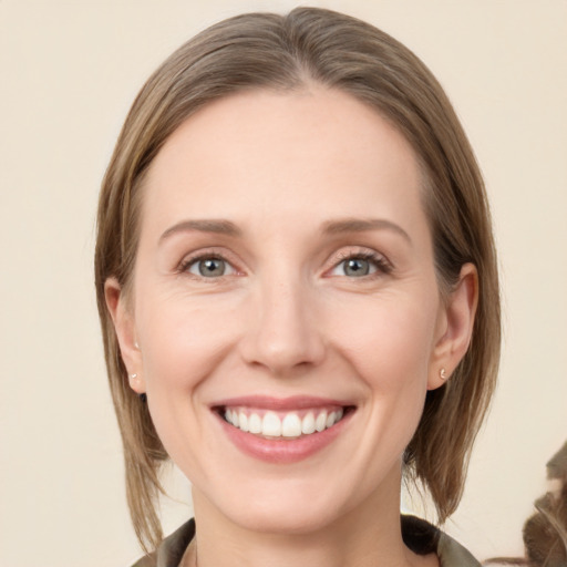 Joyful white young-adult female with medium  brown hair and green eyes