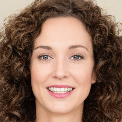 Joyful white young-adult female with long  brown hair and green eyes