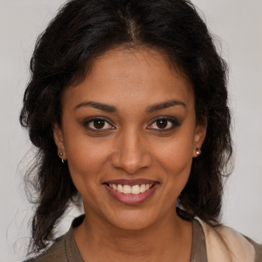 Joyful black young-adult female with long  brown hair and brown eyes