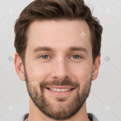 Joyful white young-adult male with short  brown hair and grey eyes