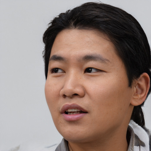 Joyful asian young-adult male with short  black hair and brown eyes