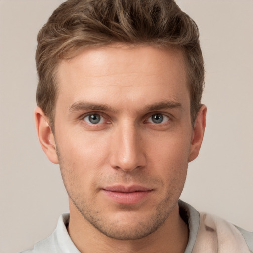 Joyful white young-adult male with short  brown hair and grey eyes