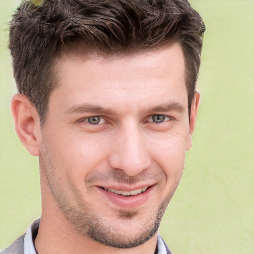 Joyful white adult male with short  brown hair and grey eyes