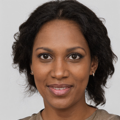 Joyful black adult female with long  brown hair and brown eyes