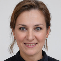 Joyful white adult female with medium  brown hair and grey eyes