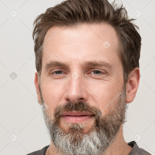 Joyful white adult male with short  brown hair and grey eyes