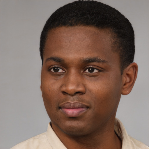Joyful black young-adult male with short  black hair and brown eyes