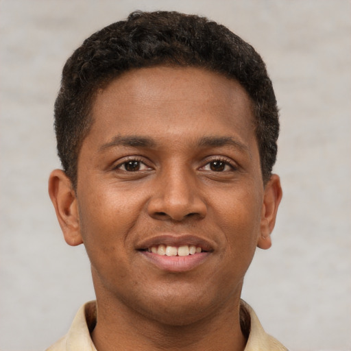 Joyful latino young-adult male with short  brown hair and brown eyes