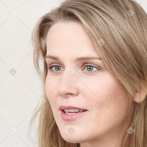 Joyful white young-adult female with long  brown hair and blue eyes