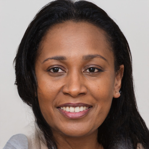 Joyful black young-adult female with long  brown hair and brown eyes