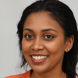 Joyful black young-adult female with long  brown hair and brown eyes