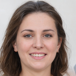 Joyful white young-adult female with long  brown hair and grey eyes