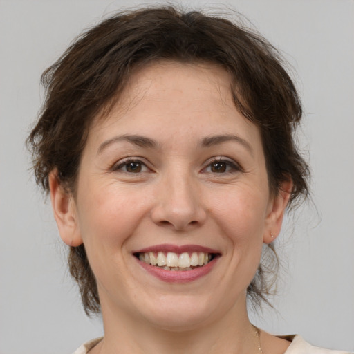 Joyful white adult female with medium  brown hair and brown eyes