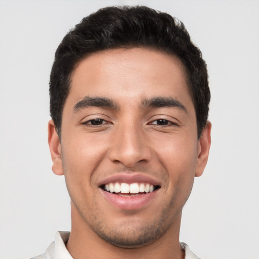 Joyful white young-adult male with short  black hair and brown eyes