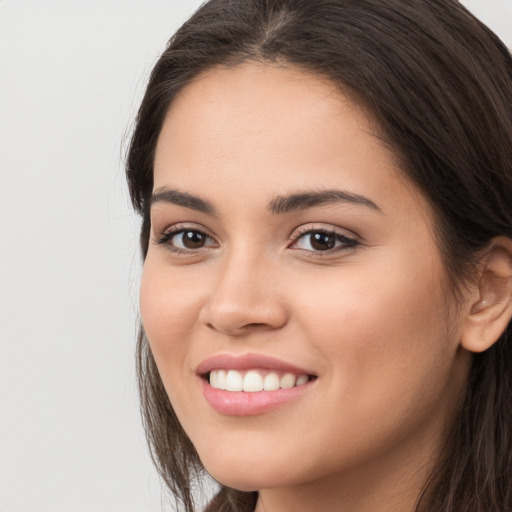 Joyful white young-adult female with long  brown hair and brown eyes