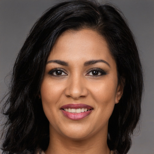 Joyful latino young-adult female with long  brown hair and brown eyes