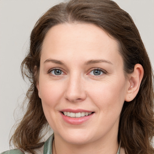 Joyful white young-adult female with long  brown hair and blue eyes