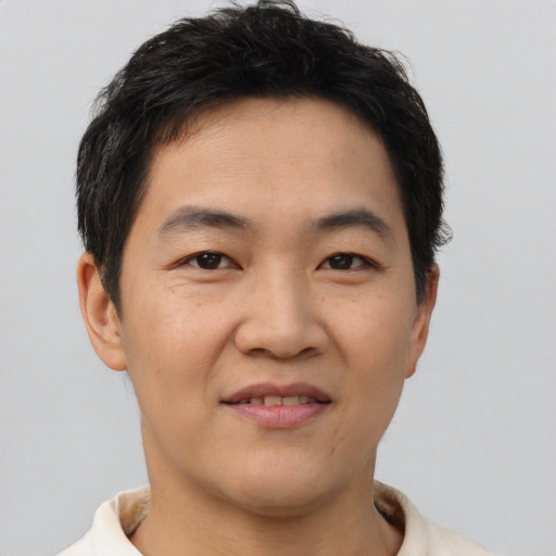 Joyful asian young-adult male with short  black hair and brown eyes