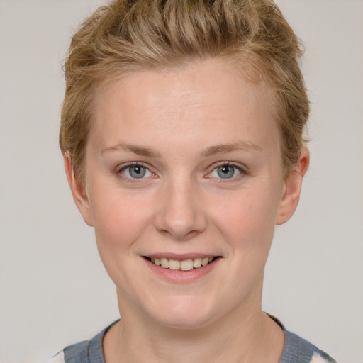 Joyful white young-adult female with short  brown hair and blue eyes