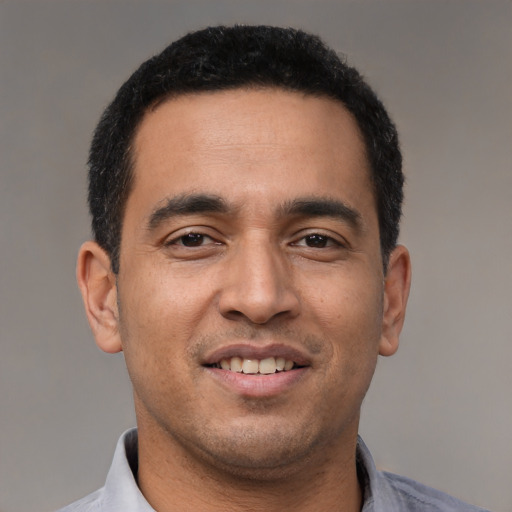 Joyful latino young-adult male with short  black hair and brown eyes