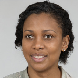 Joyful black adult female with short  brown hair and brown eyes