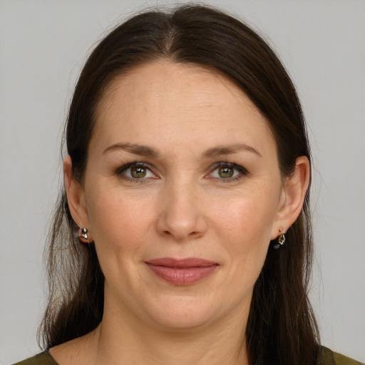 Joyful white adult female with long  brown hair and green eyes