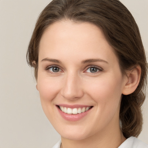 Joyful white young-adult female with medium  brown hair and green eyes