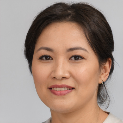Joyful asian adult female with medium  brown hair and brown eyes