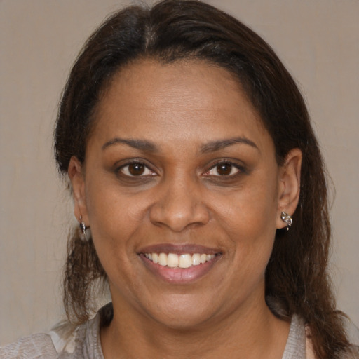 Joyful black adult female with medium  brown hair and brown eyes
