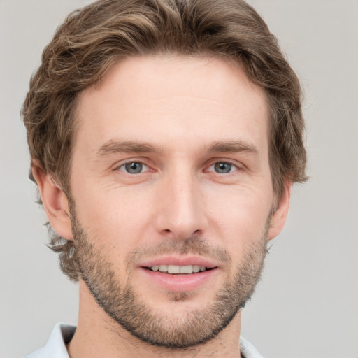 Joyful white young-adult male with short  brown hair and grey eyes