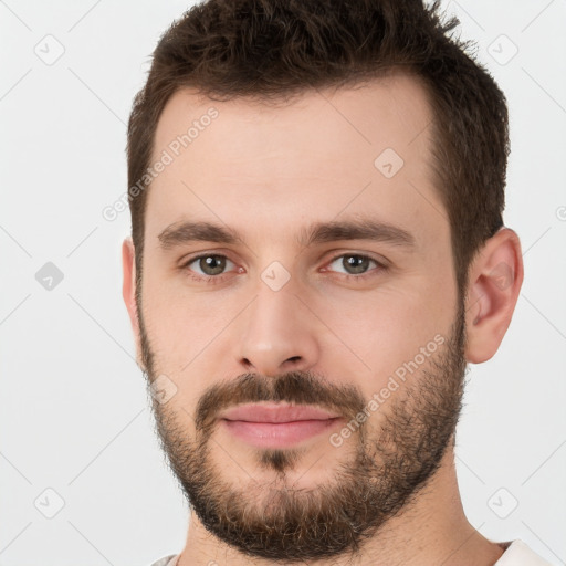 Joyful white young-adult male with short  brown hair and brown eyes