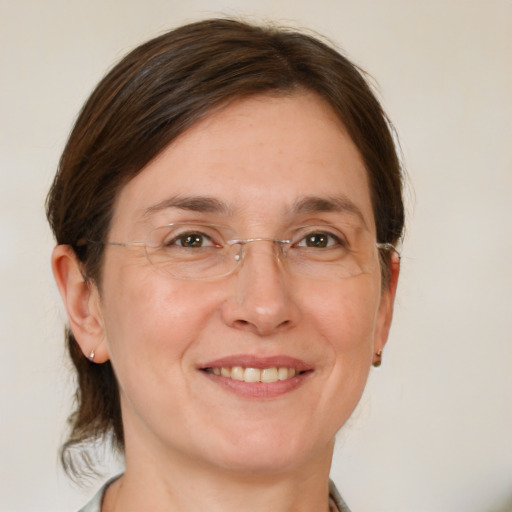 Joyful white adult female with medium  brown hair and green eyes