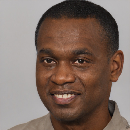 Joyful black adult male with short  brown hair and brown eyes