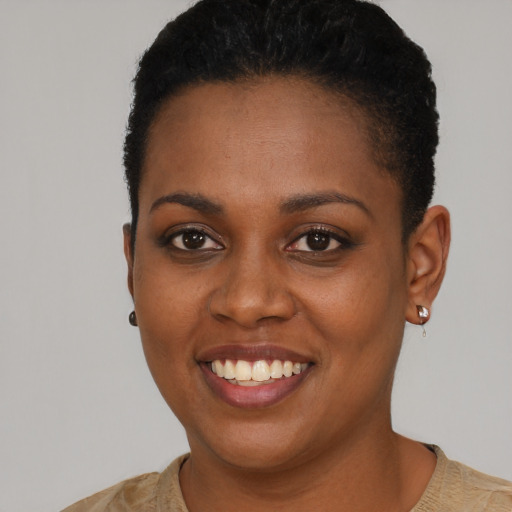 Joyful black young-adult female with short  brown hair and brown eyes
