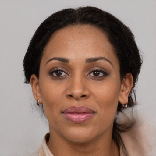 Joyful latino adult female with medium  brown hair and brown eyes