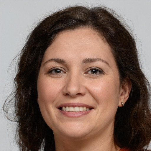 Joyful white adult female with long  brown hair and brown eyes