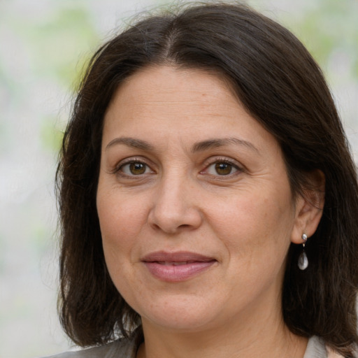 Joyful white adult female with medium  brown hair and grey eyes