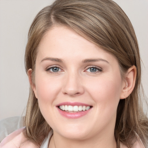 Joyful white young-adult female with medium  brown hair and grey eyes