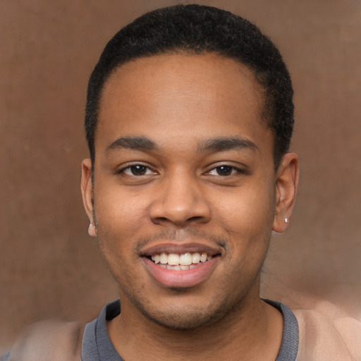 Joyful black young-adult male with short  brown hair and brown eyes