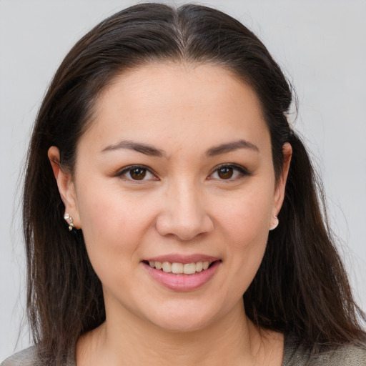 Joyful white young-adult female with long  brown hair and brown eyes