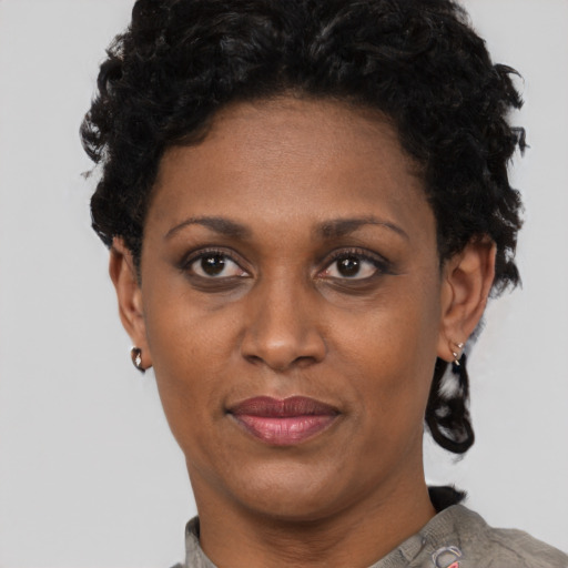 Joyful black adult female with short  black hair and brown eyes