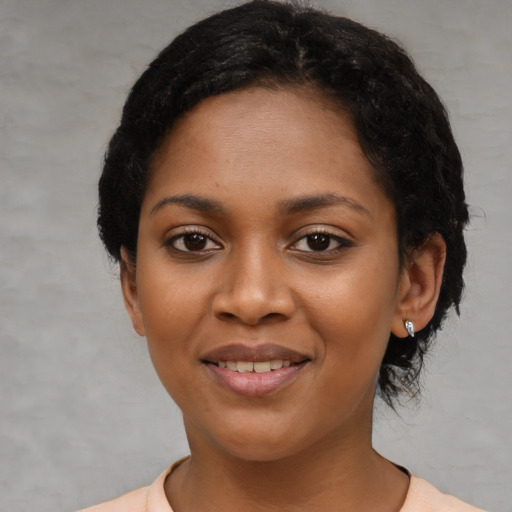 Joyful black young-adult female with short  black hair and brown eyes
