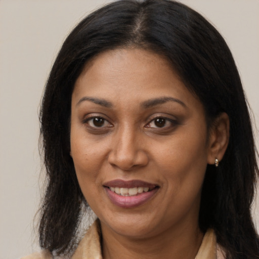 Joyful black adult female with long  brown hair and brown eyes