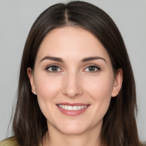 Joyful white young-adult female with long  brown hair and brown eyes