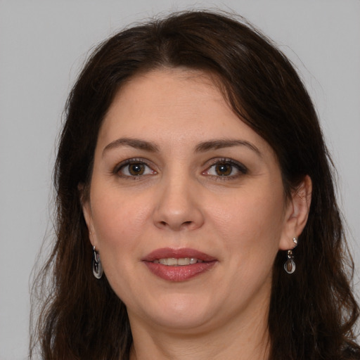 Joyful white adult female with long  brown hair and brown eyes