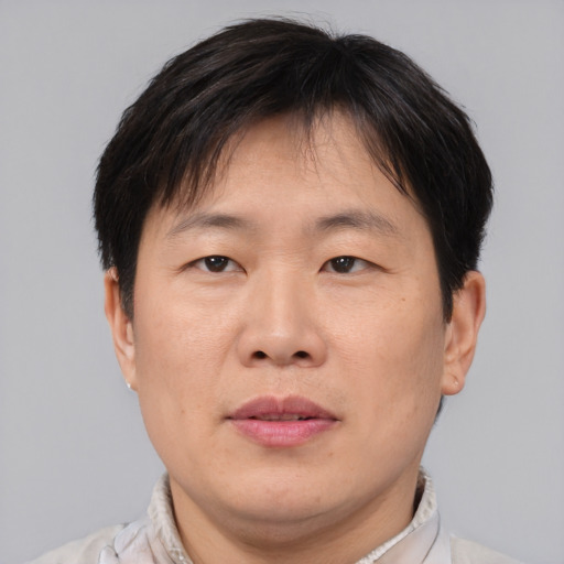 Joyful asian adult male with short  brown hair and brown eyes