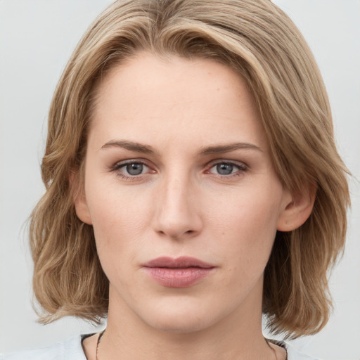 Joyful white young-adult female with medium  brown hair and green eyes