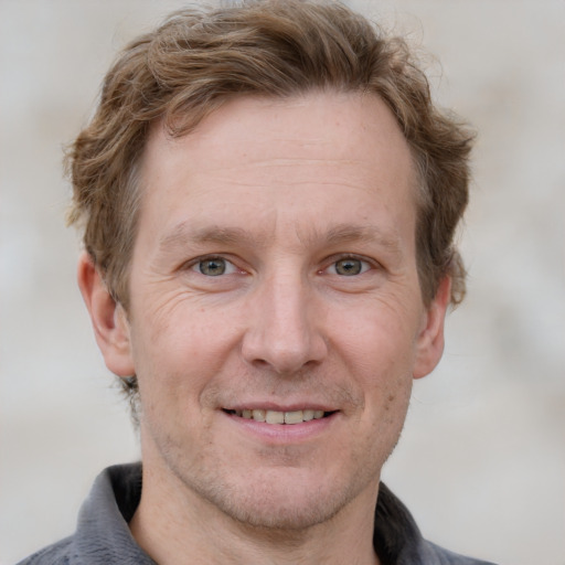 Joyful white adult male with short  brown hair and grey eyes